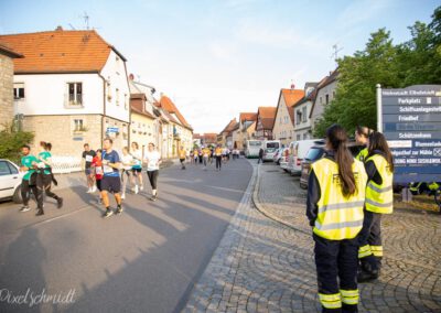 Die Läufer auf der Strecke und die Helfer der Freiwilligen Feuerwehr